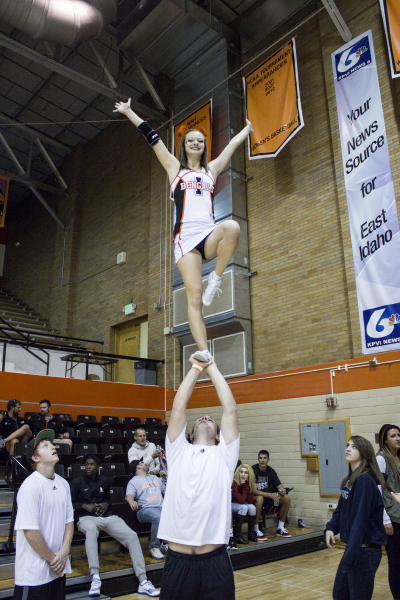 Lyttia O’Neil performs a partner “liberty”  stunt during a volleyball game.