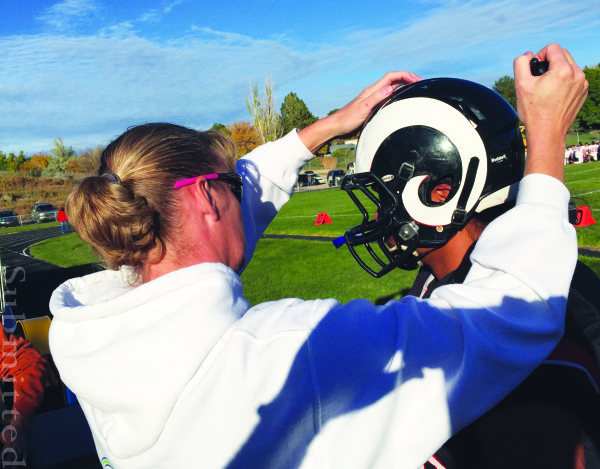 Caroline Faure checks an athlete’s helmet.