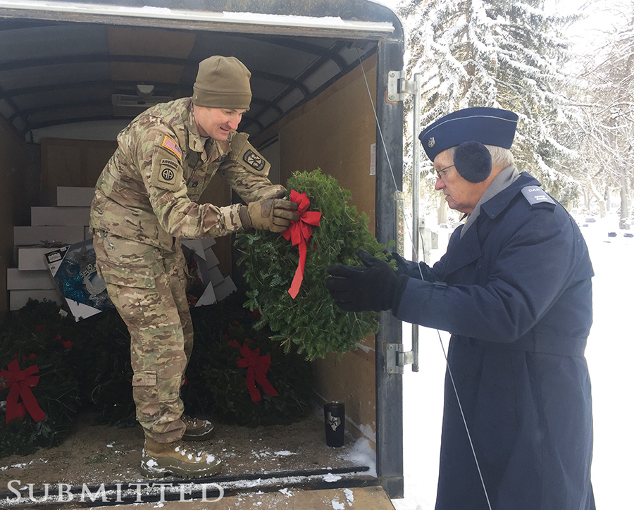 Cadet passing a wreath to soldier