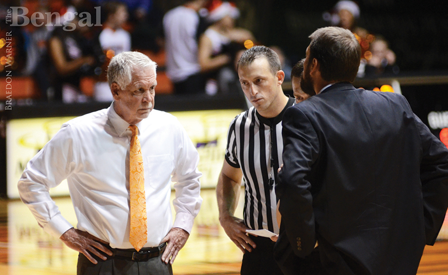 One referee and three other men on basketball court.