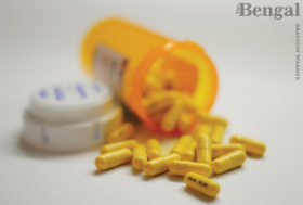 Prescription drug bottle with pills spilling out.