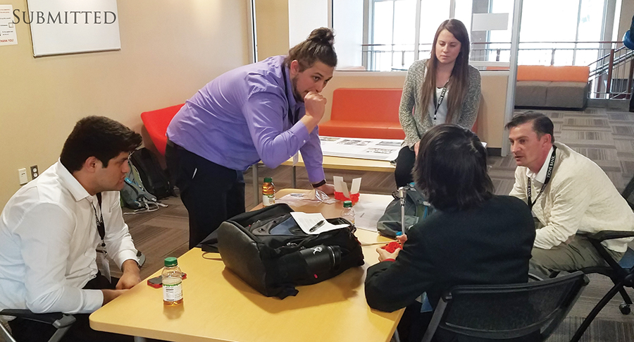 Five students sitting at a table. 