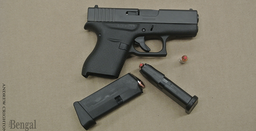 Handgun with two magazines and an extra bullet.