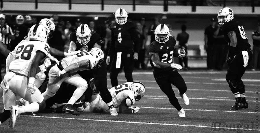 ISU #23 running with football during game.