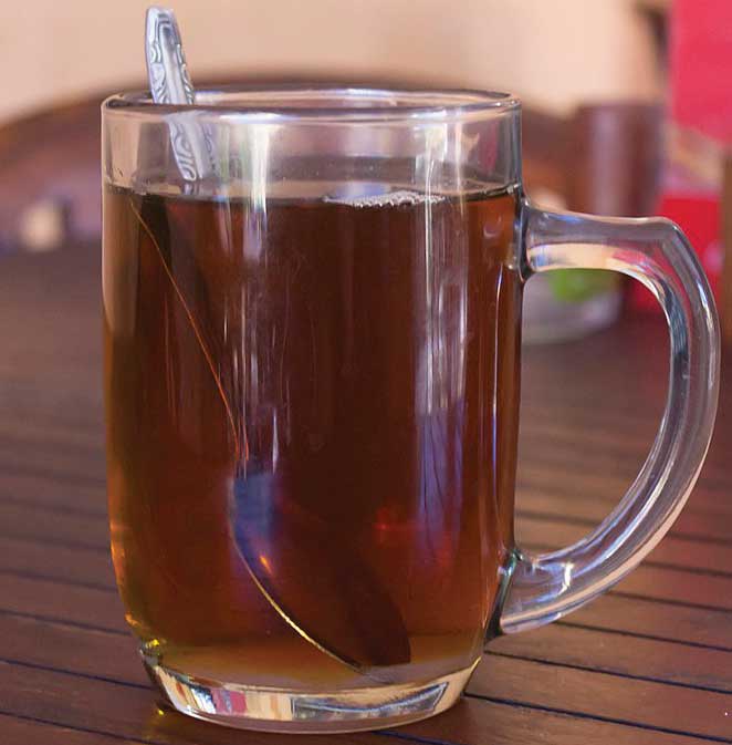 Hot buttered rum and spoon in a clear mug