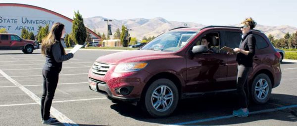 Person stands in front of red car.