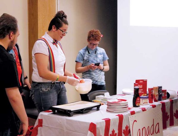 ISU students representing Canada make pancakes for All Around the World Night.