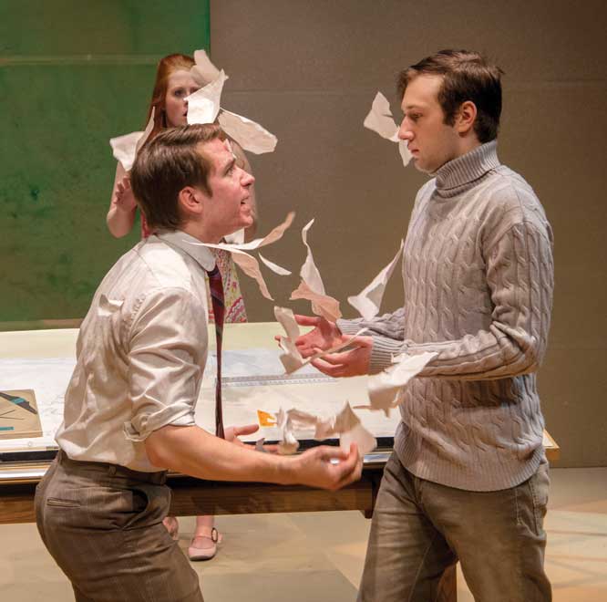 Two male actors face each other in distress while female actor stands behind.