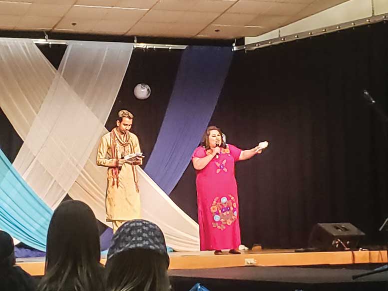 A man and a woman stand on stage at International Night.