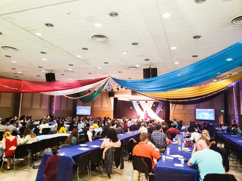People sit at table in chairs at International Night.