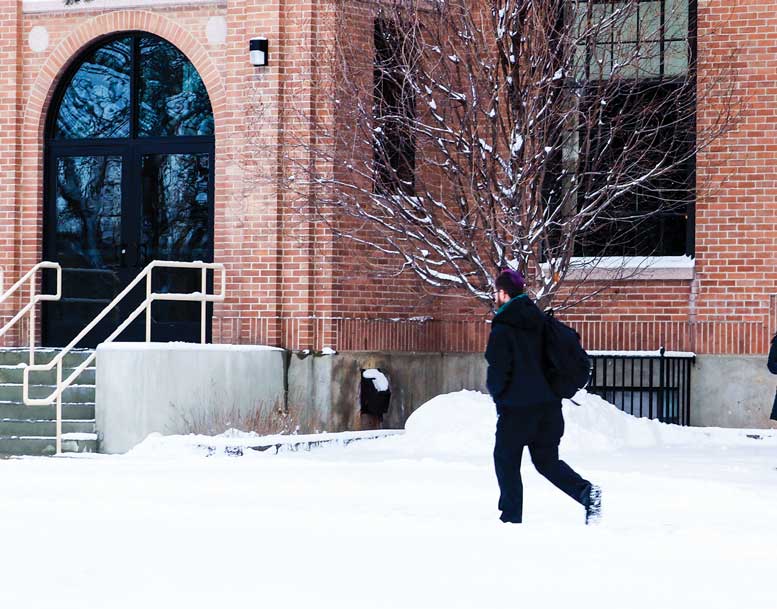 Student walks across snow covered quad