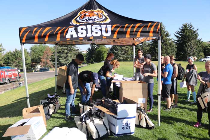 Participants stand at pop up tent to get swag