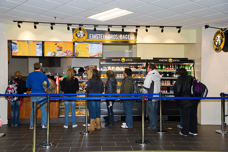 People stabnd in line in front of Einstein's Bagels