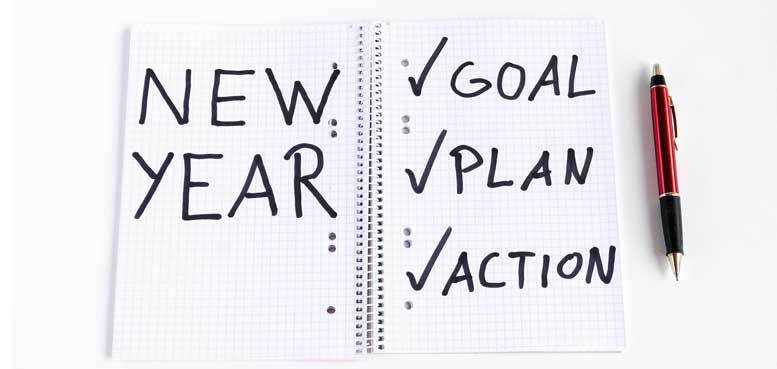 "New year, goals, plan, action" written on a notebook