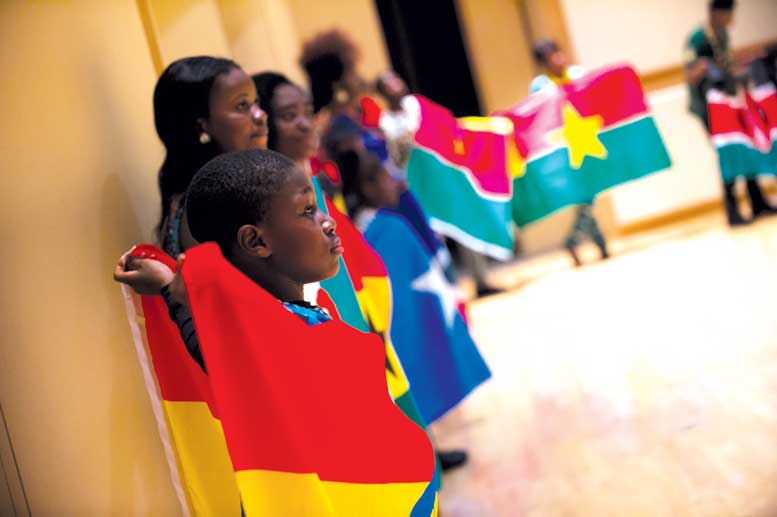 Students stand in a line holding up flags from countries in Africa