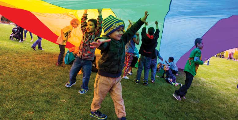 Children play under rainbow canopy