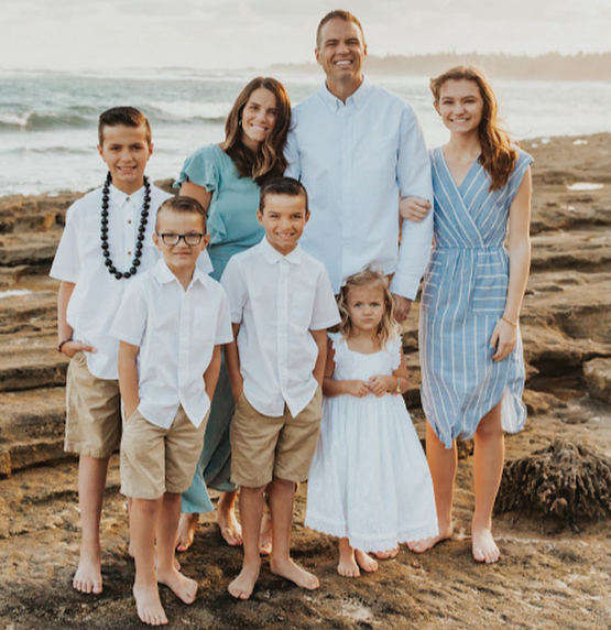 Bingham family stands onbeach for family portrait.