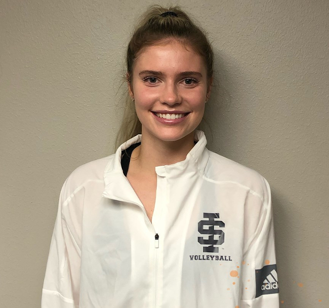 Haylie Keck stands in front of a black wall, wearing a white athletic quarter zip with an ISU logo on the front.