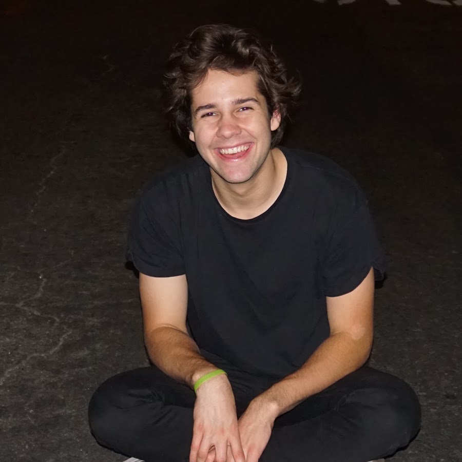 David Dobrik sits criss-cross on the groun.