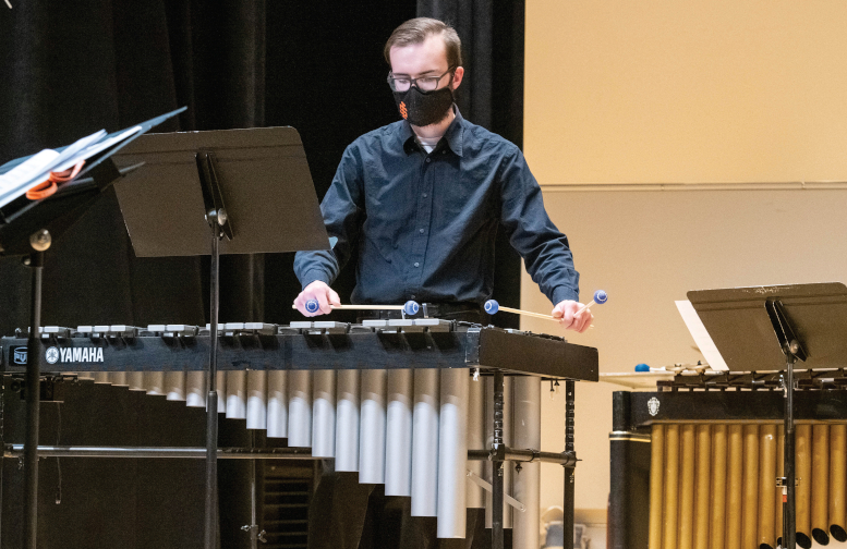 Percussionist with mask on plays vibraphone
