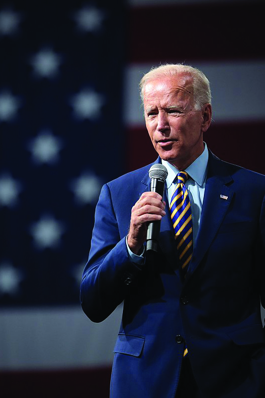 Joe Biden with microphone, American flag in background