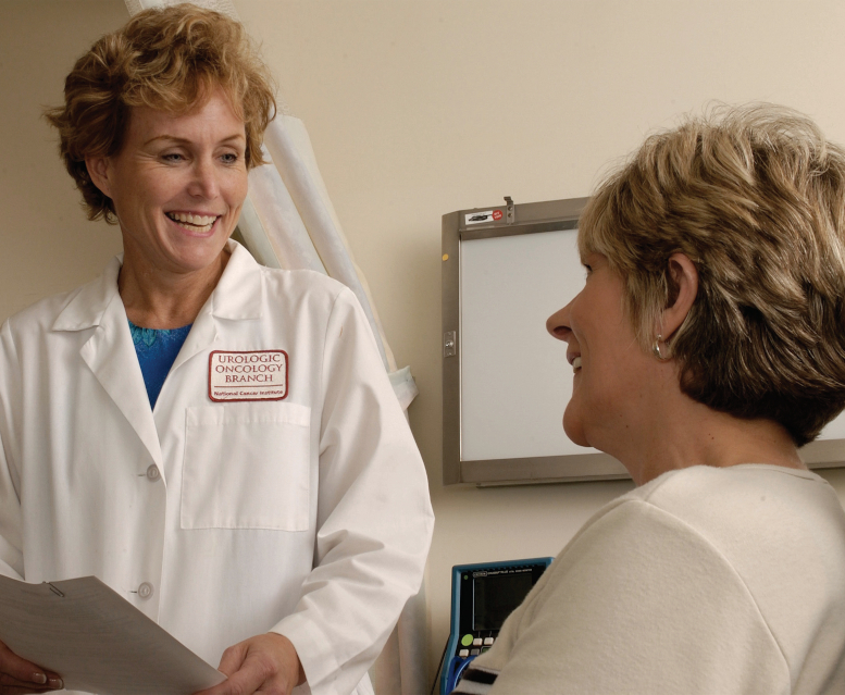 Woman in white coat talks with female patient.
