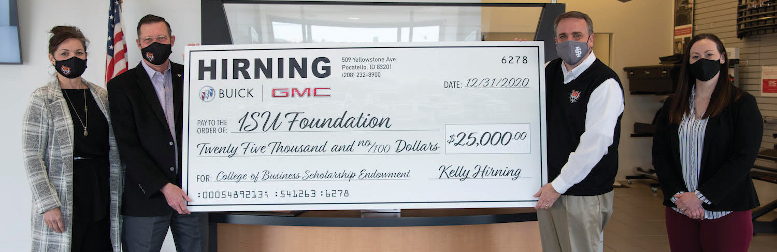 Four people hold up check for $25,000 up for the camera