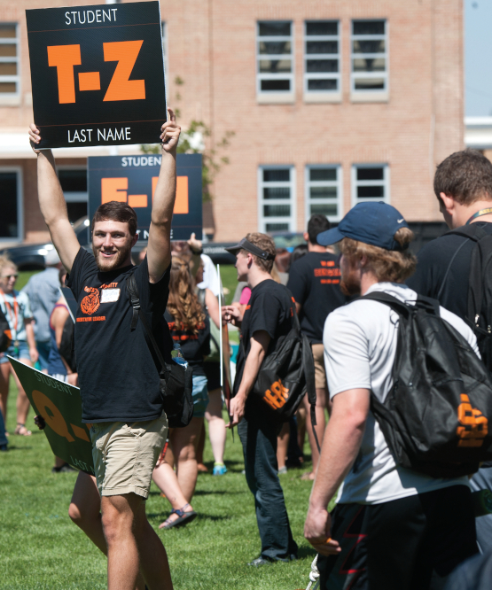 ISU student holds sign reading "Student Last Name T-Z" above his head