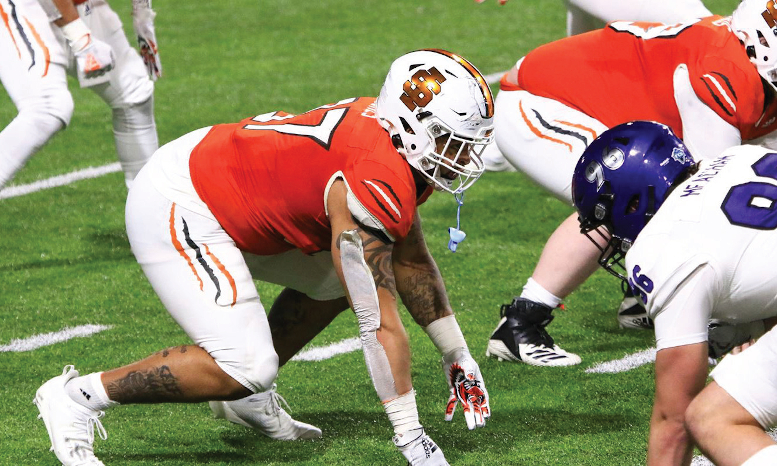 Football players crouch at line of scrimmage