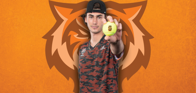 Patrik Trhac holds tennis ball out towards camera