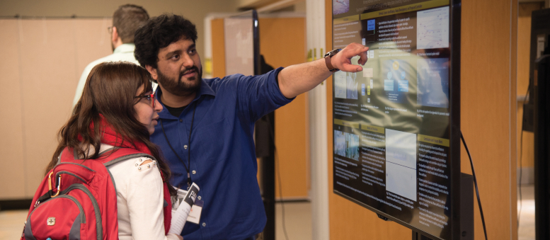 Man and woman look at poster together
