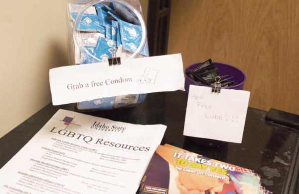 Condoms in bowl and informational papers on table