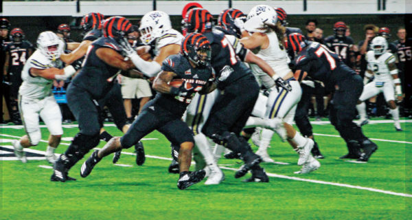 ISU football player tackled. Other players surrounding and in background.