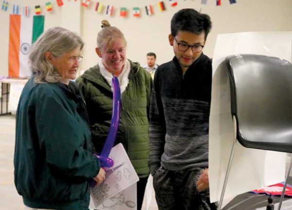 Three people look at display.