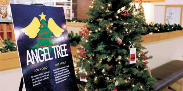 Angel tree sign stands next to Christmas tree in PSUB.