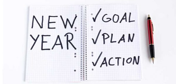 "New year, goals, plan, action" written on a notebook